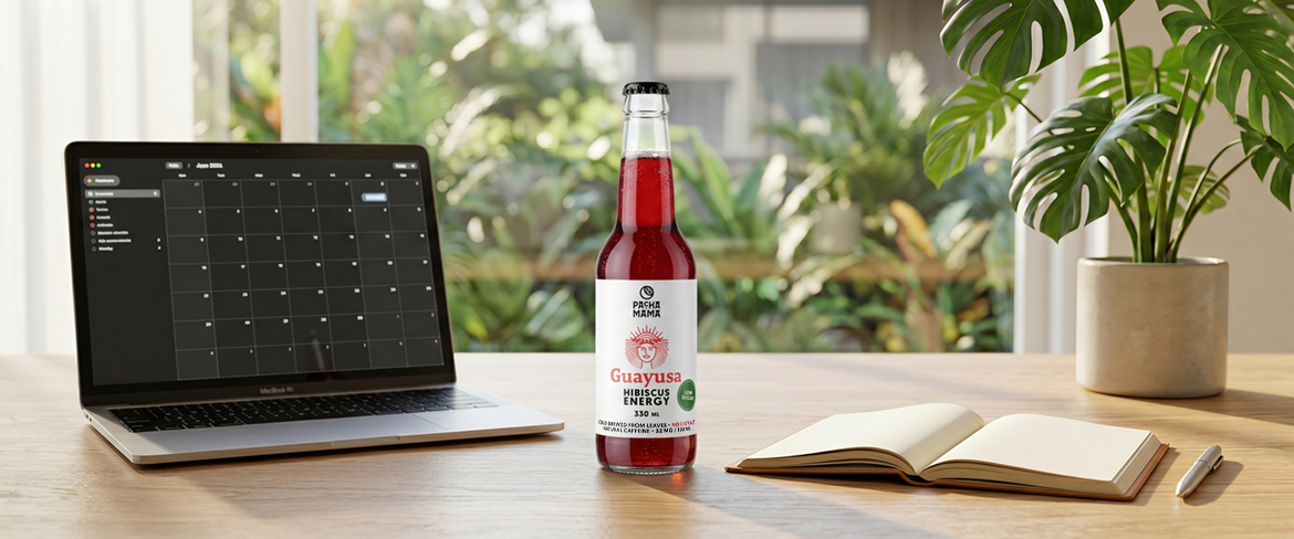 Egy üveg guayusa egy laptop mellett az íróasztalon – egy praktikus guayusa-ital, amely segít a munkában való koncentrációban.